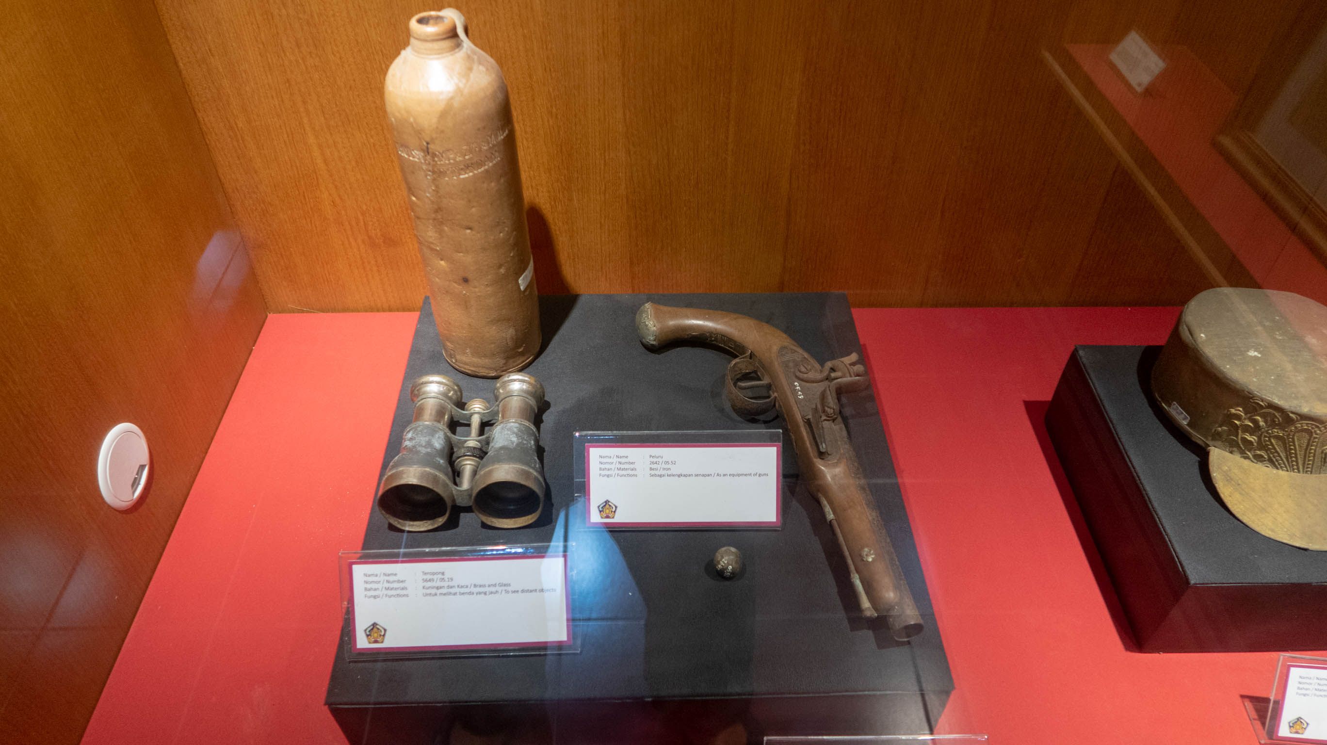 A binocular, bullets, pistol and a bronze hat. 