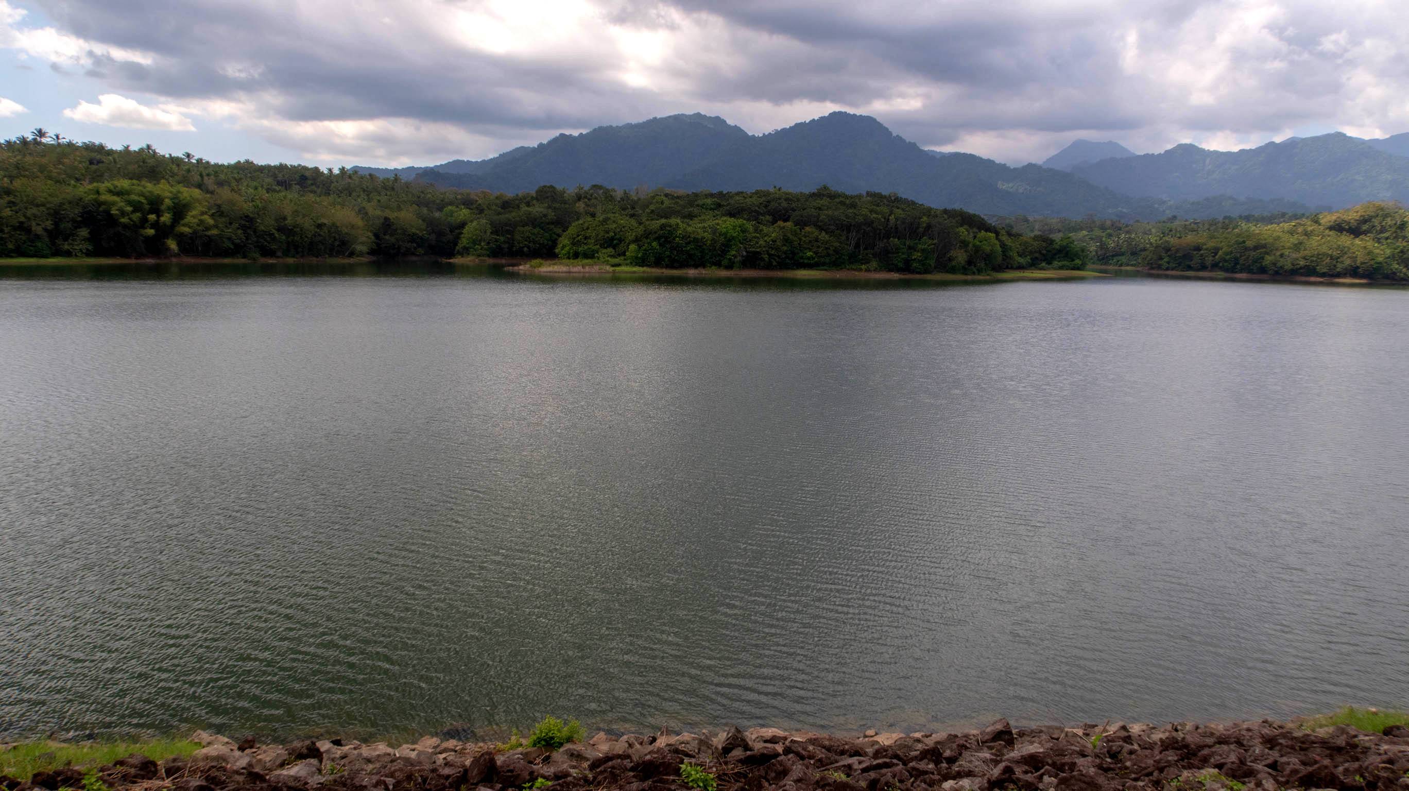 The view of the Palasari Dam with forest and hills beyond