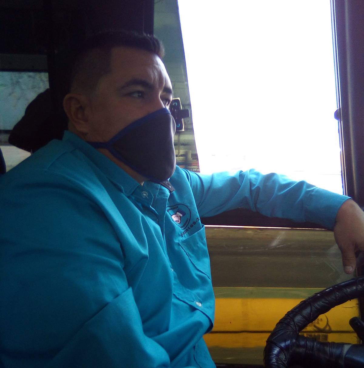 The bus driver wearing a mask.