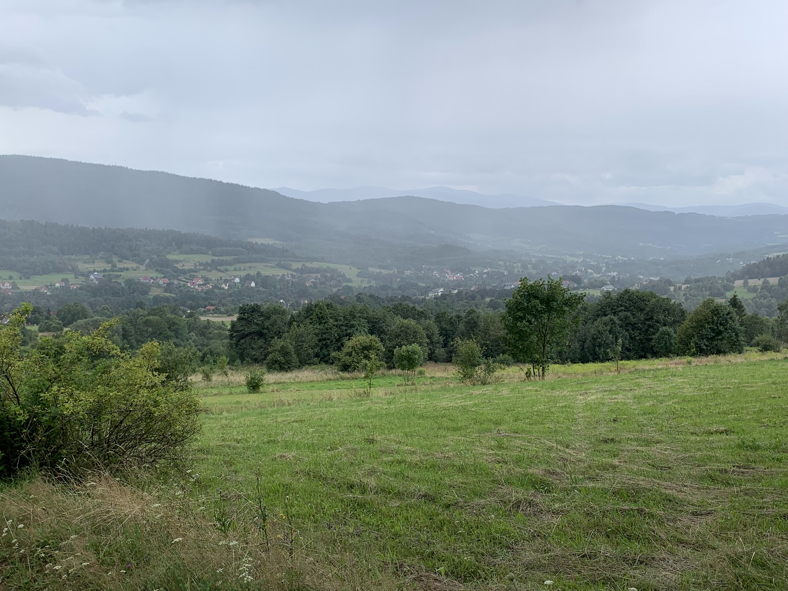 Widok z Babicy Zachodniej. W dole Bieńkówka, w oddali zamglona Babia Góra i Polica.