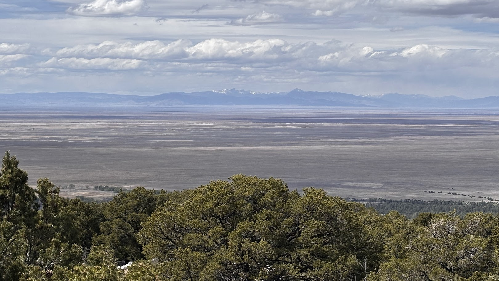 San Luis valley viewed from Zapata Falls Trailhead. San Juan mountains rise from the flat valley bottom